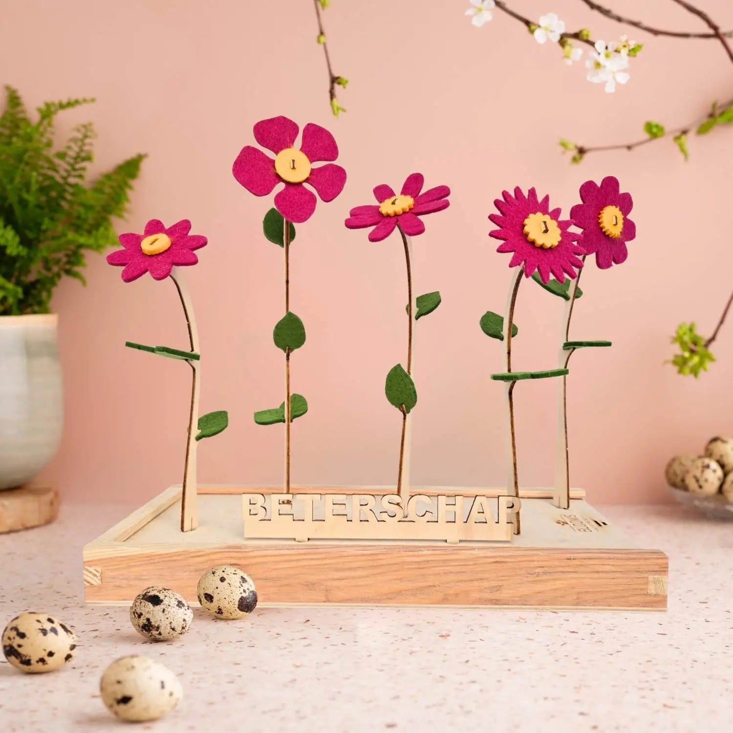 Bloemcadeau met vilten bloemen in cerise en 'beterschap'-bordje.