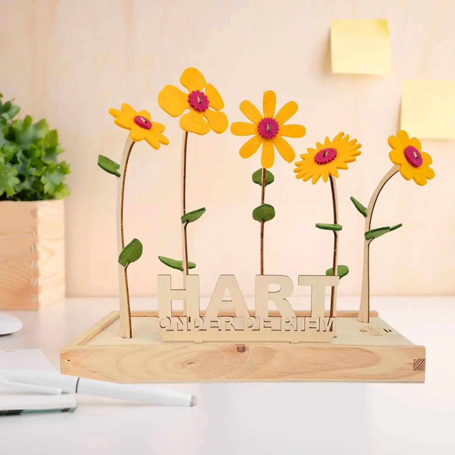 Vilten bloemen van Happy Blooms in het geel met bordje 'hart onder de riem'. 