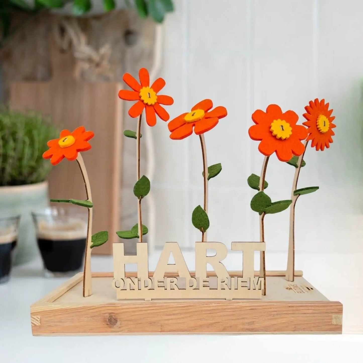 Vilten bloemen van Happy Blooms in het oranje met bordje 'hart onder de riem'. 
